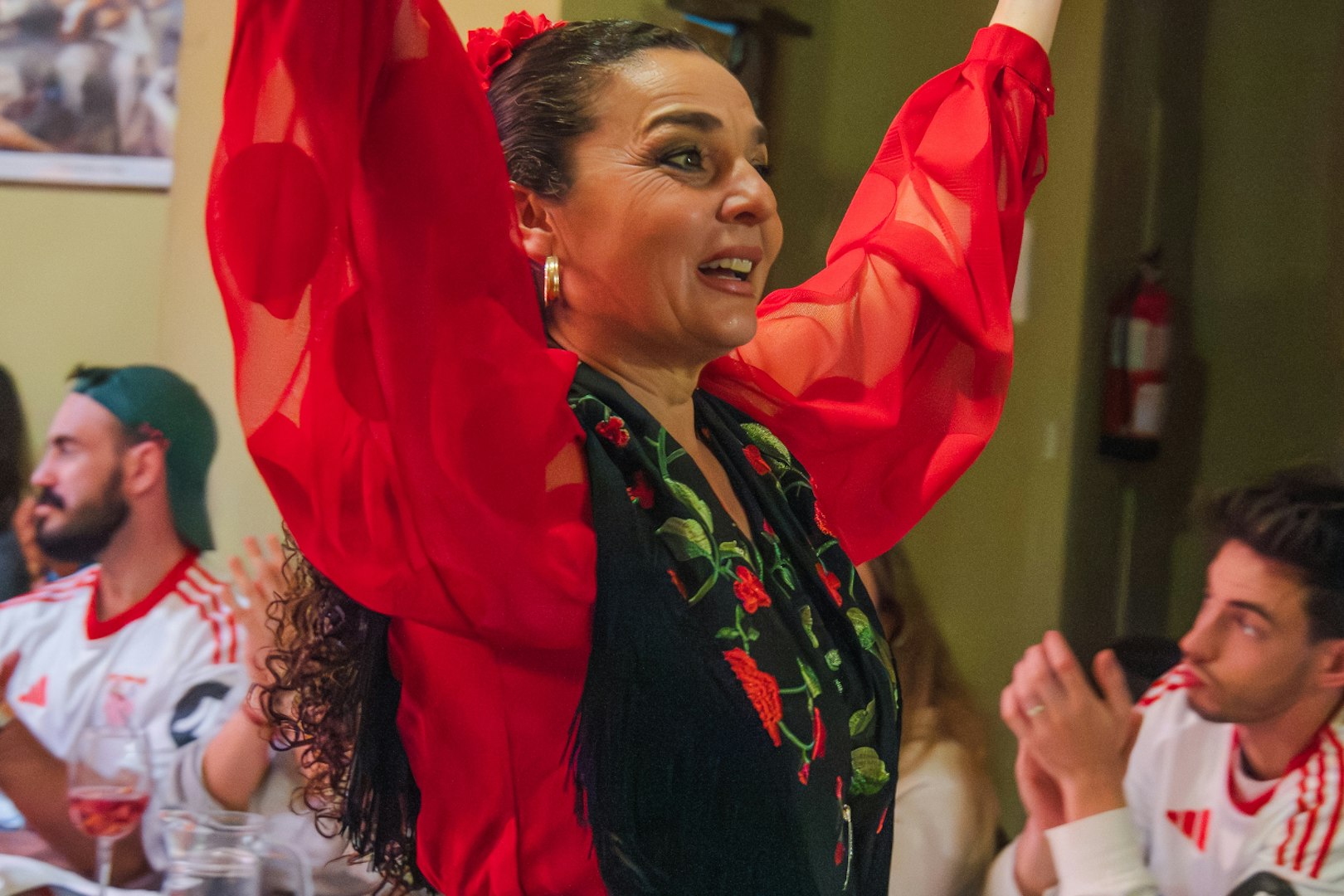 Flamenco dancer performing at Tablao La Cantaora, Seville, with audience clapping.