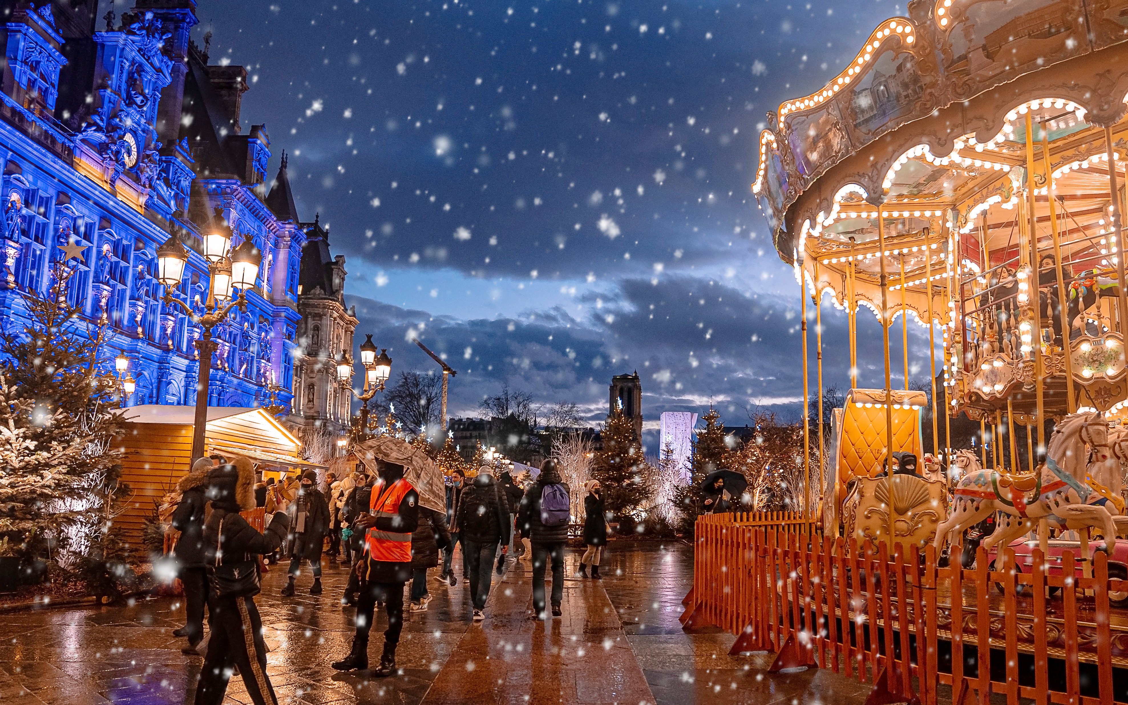 Paris Christmas market with carousel and festive lights at night.