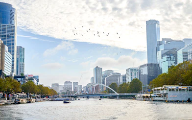 Melbourne skyline with boats on Yarra River during a river cruise.