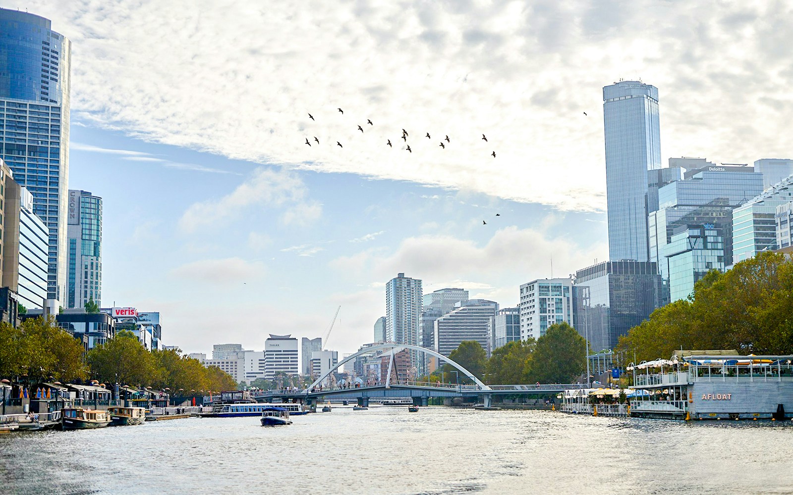 Melbourne skyline with boats on Yarra River during a river cruise.