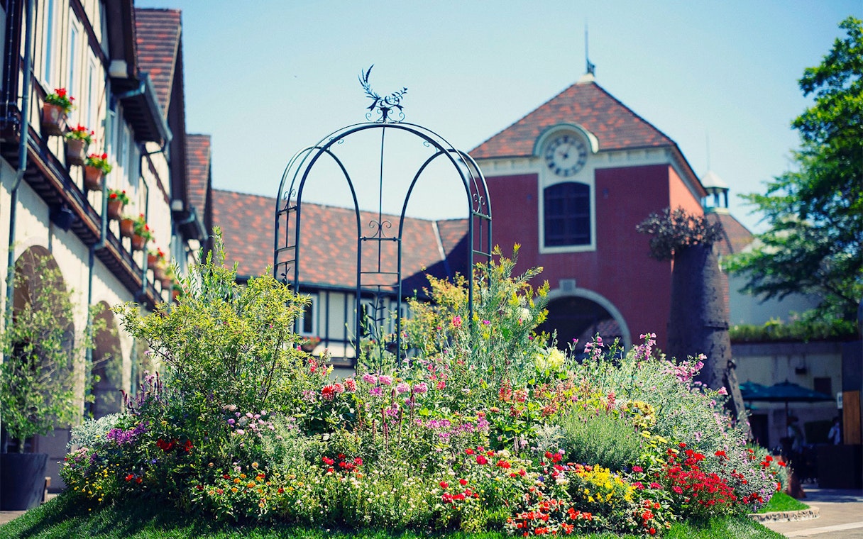 Kobe Nunobiki Herb Gardens with colorful flowers and a scenic building backdrop.