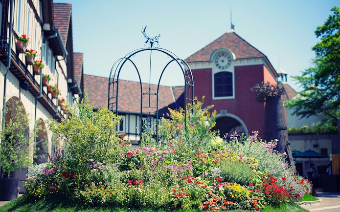 Kobe Nunobiki Herb Gardens with colorful flowers and a scenic building backdrop.