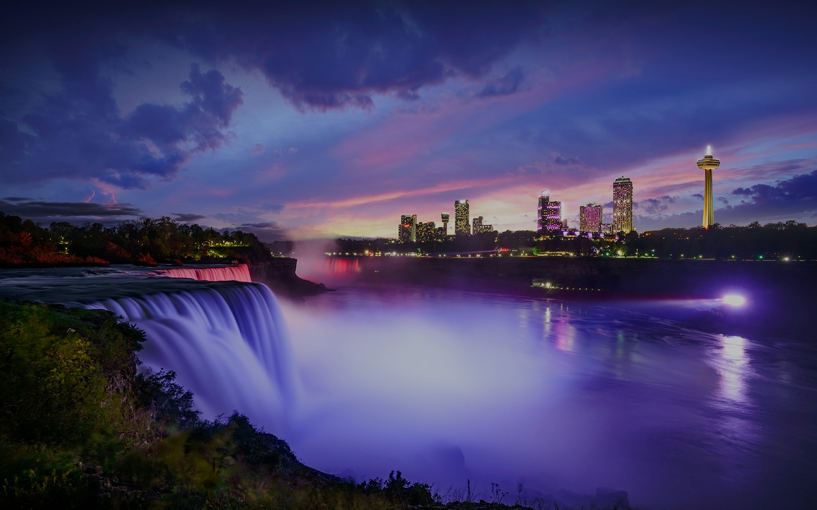 Chutes du Niagara de nuit avec la ville en arrière-plan - Croisière Hornblower