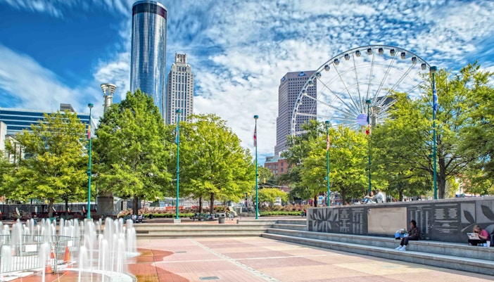 Centennial Olympic Park with fountain, trees, and Ferris wheel in Atlanta, Georgia.