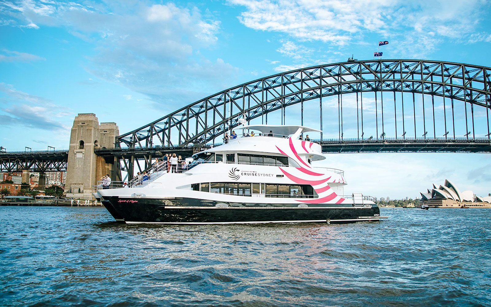 Spirit of Migloo sailing on Sydney Harbour with Sydney Harbour Bridge in the background.