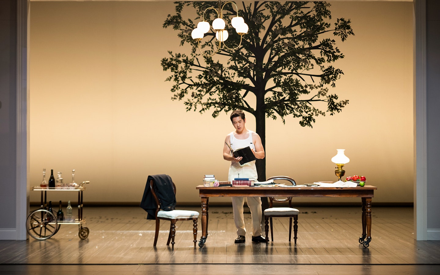 Sydney Opera House performance of La Traviata with actor reading at a table.