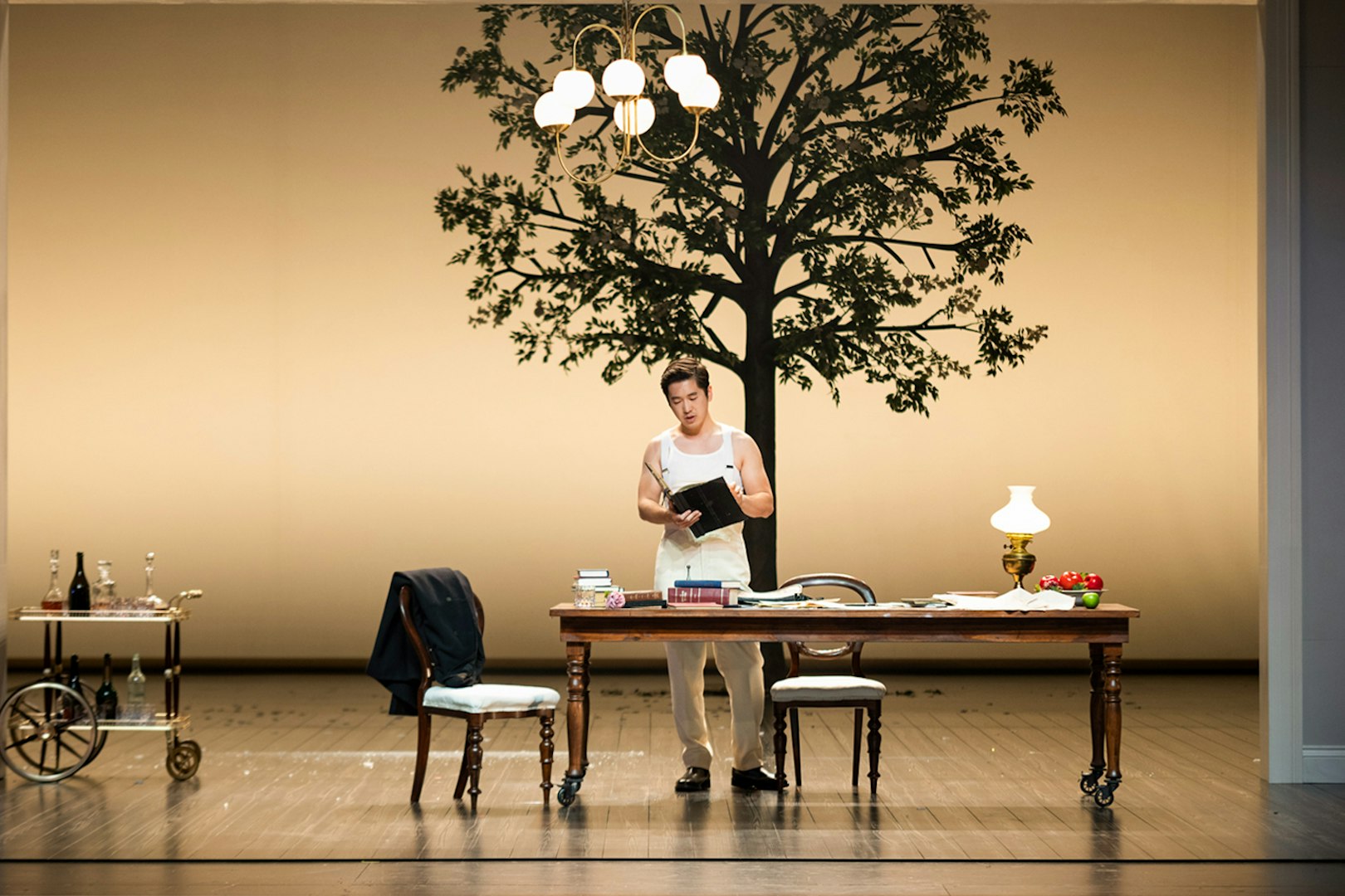 Sydney Opera House performance of La Traviata with actor reading at a table.