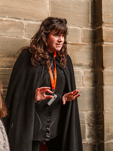 Tour guide leading Edinburgh's Royal Mile ghost tour with guests.