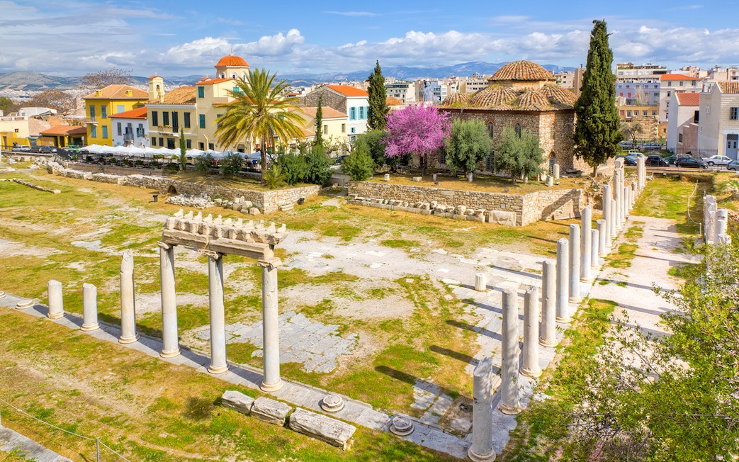 Roman Agora ruins with columns and ancient structures in Athens, Greece.