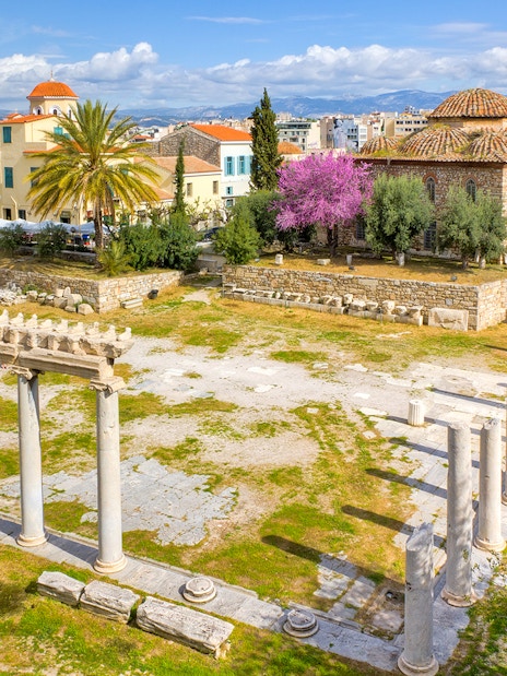 Roman Agora ruins with columns and ancient structures in Athens, Greece.
