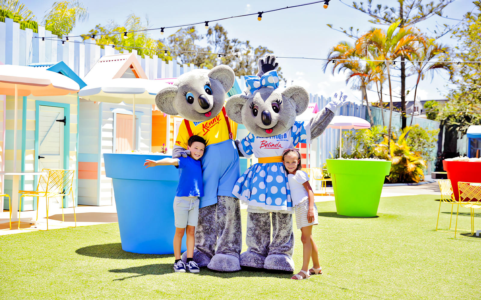 Two kids with Kenny and Belinda mascots at Dreamland theme park.