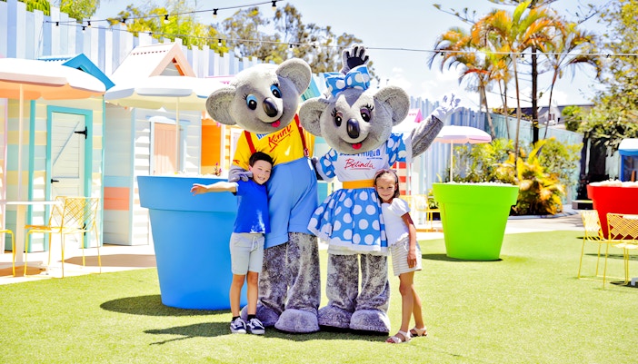 Two kids with Kenny and Belinda mascots at Dreamland theme park.