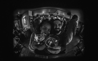 Couple enjoying drinks at a lively bar during Reykjavík private bar crawl.