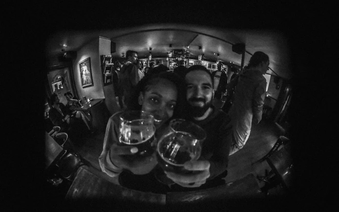 Couple enjoying drinks at a lively bar during Reykjavík private bar crawl.