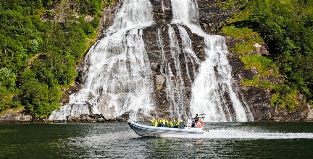 RIB boat on Geiranger Fjord near Seven Sisters waterfall, Norway.