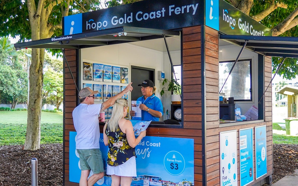 Gold Coast ferry ticket booth with visitors receiving information for hop on hop off cruise.