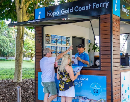 Biglietteria dei traghetti della Gold Coast con visitatori che ricevono informazioni sulla crociera Hop-on Hop-off.