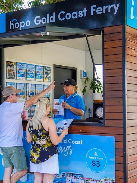 Gold Coast ferry ticket booth with visitors receiving information for hop on hop off cruise.