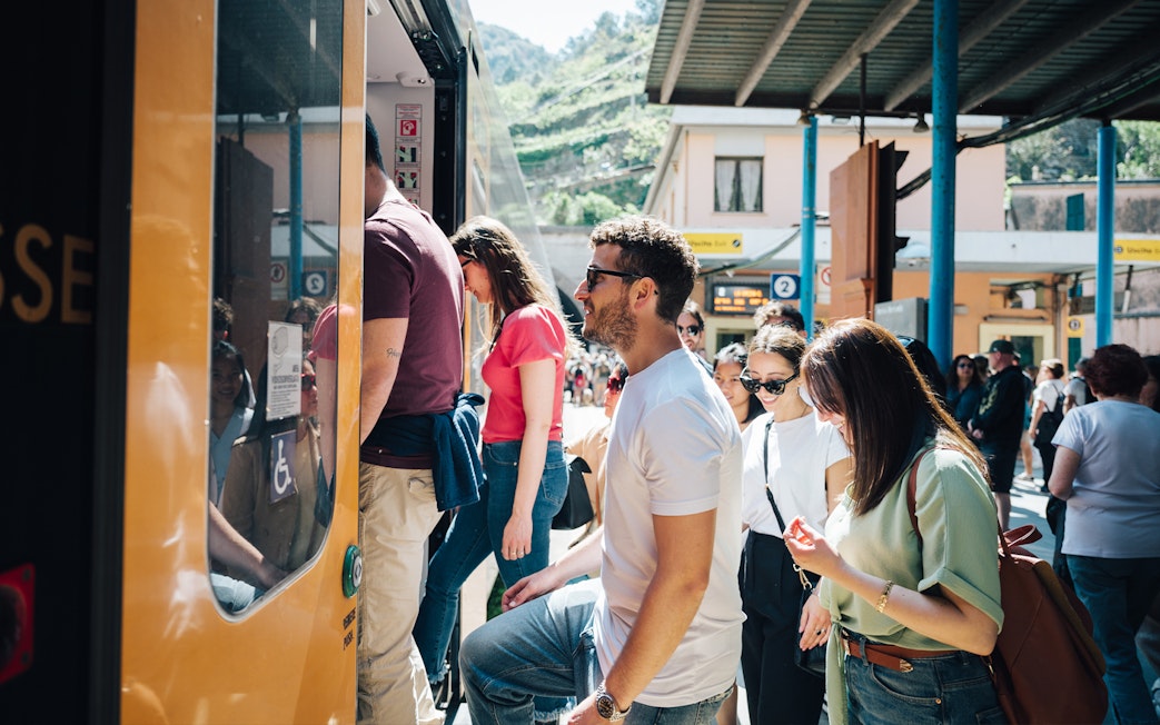 Tourists boarding a train at a Cinque Terre station, Italy.