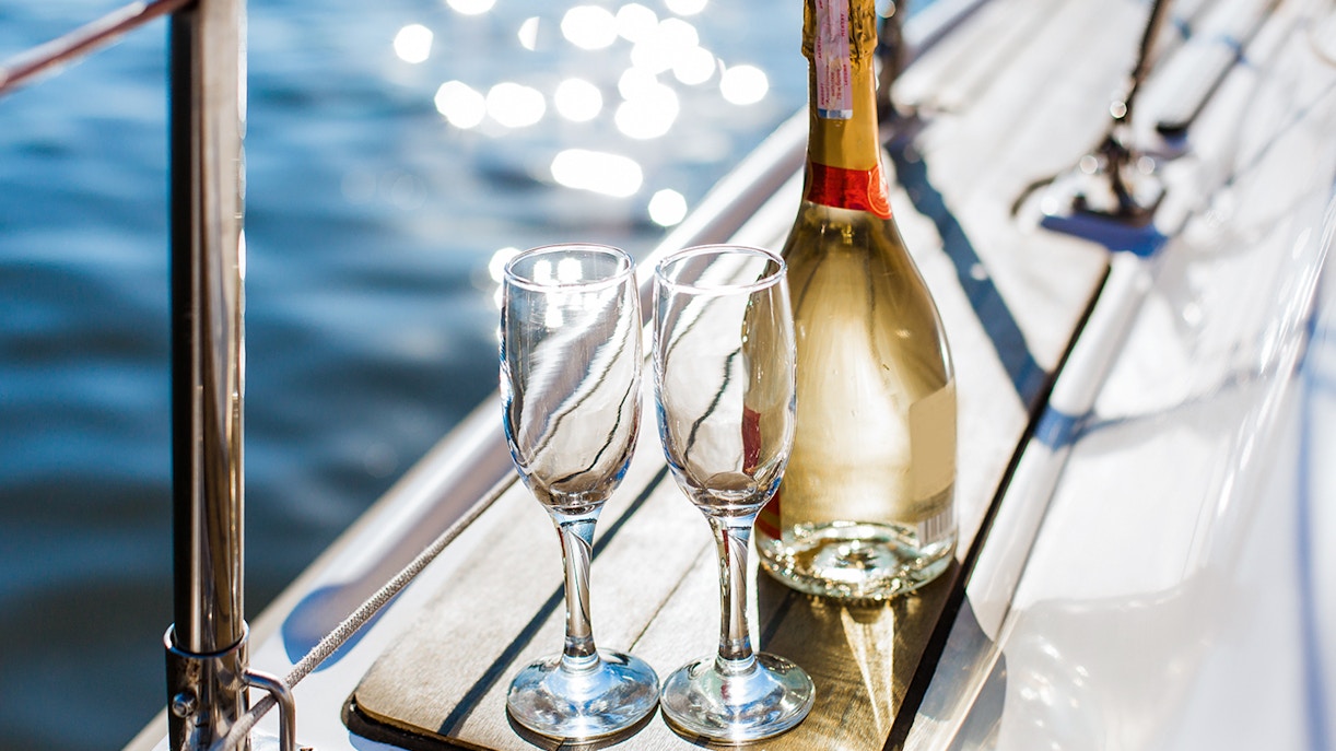 Champagne bottle and glasses on a boat deck during Syracuse tour.