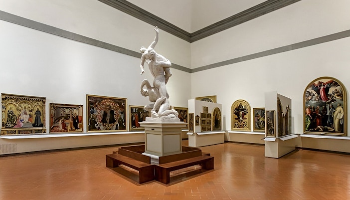 Visitors viewing Michelangelo's David sculpture at Accademia Gallery, Florence, with timed entry tickets.