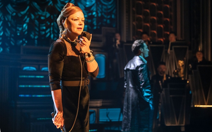 Performer on stage with microphone during a theatrical show.