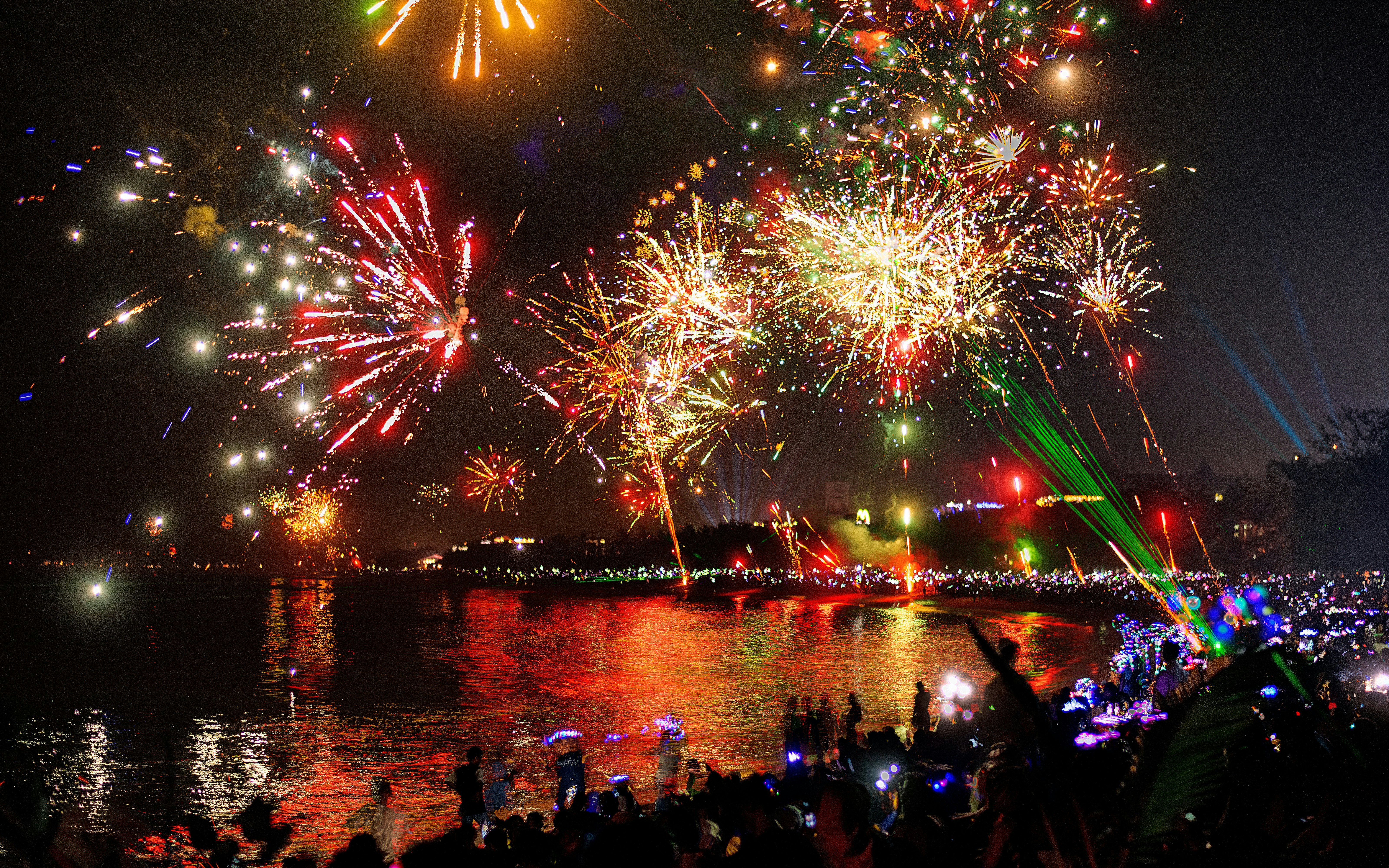 Fireworks display over a crowded beach during New Year's Eve in Bali.