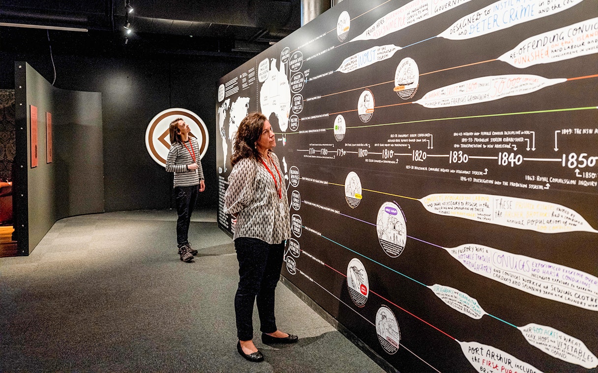 Visitors examining historical timeline at Port Arthur Gallery, Port Arthur Historic Site.