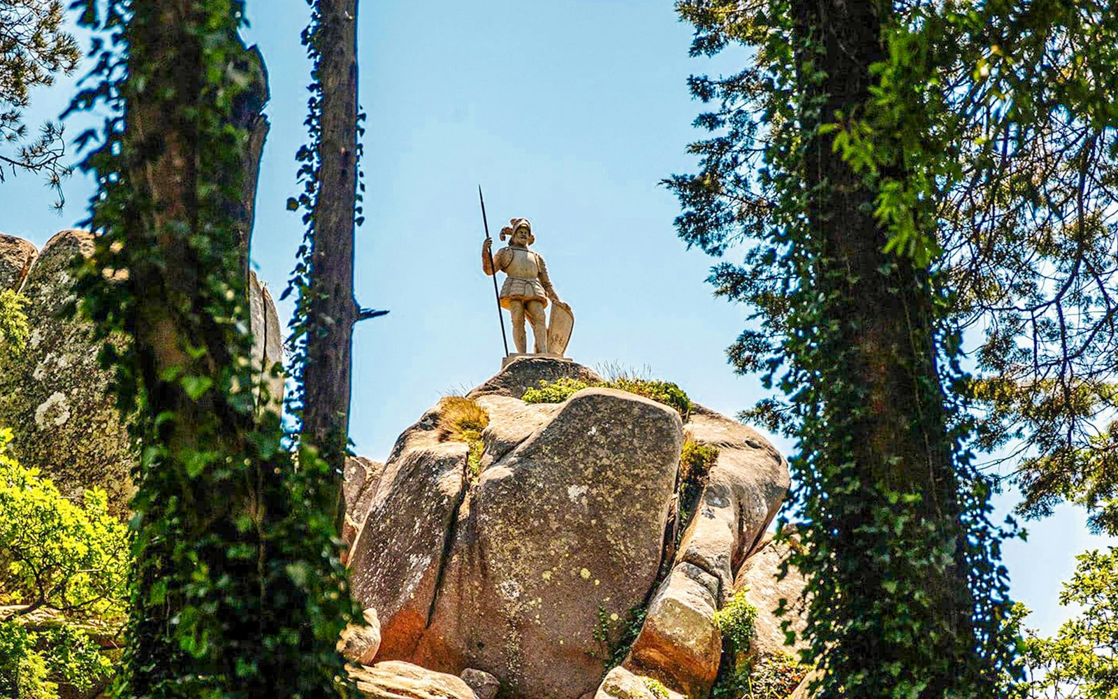 Statue of the Warrior in Pena Palace Park, Sintra, Portugal, surrounded by lush greenery.