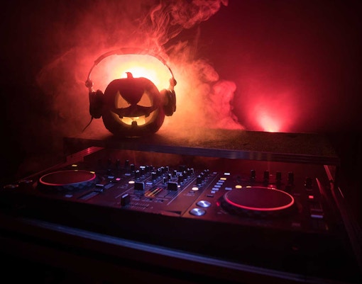 DJ booth with pumpkin wearing headphones at Upside Down Oktoberfest Party, Snow City.