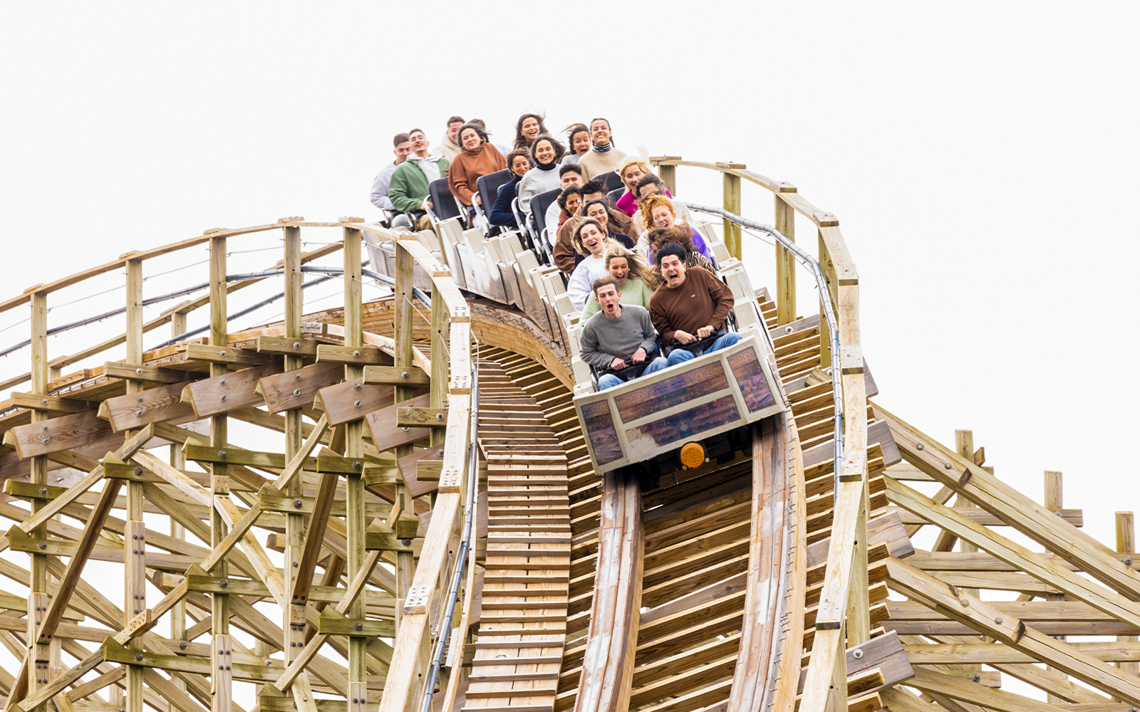 Riders on Coaster Express at Parque Warner Madrid descending a wooden track.