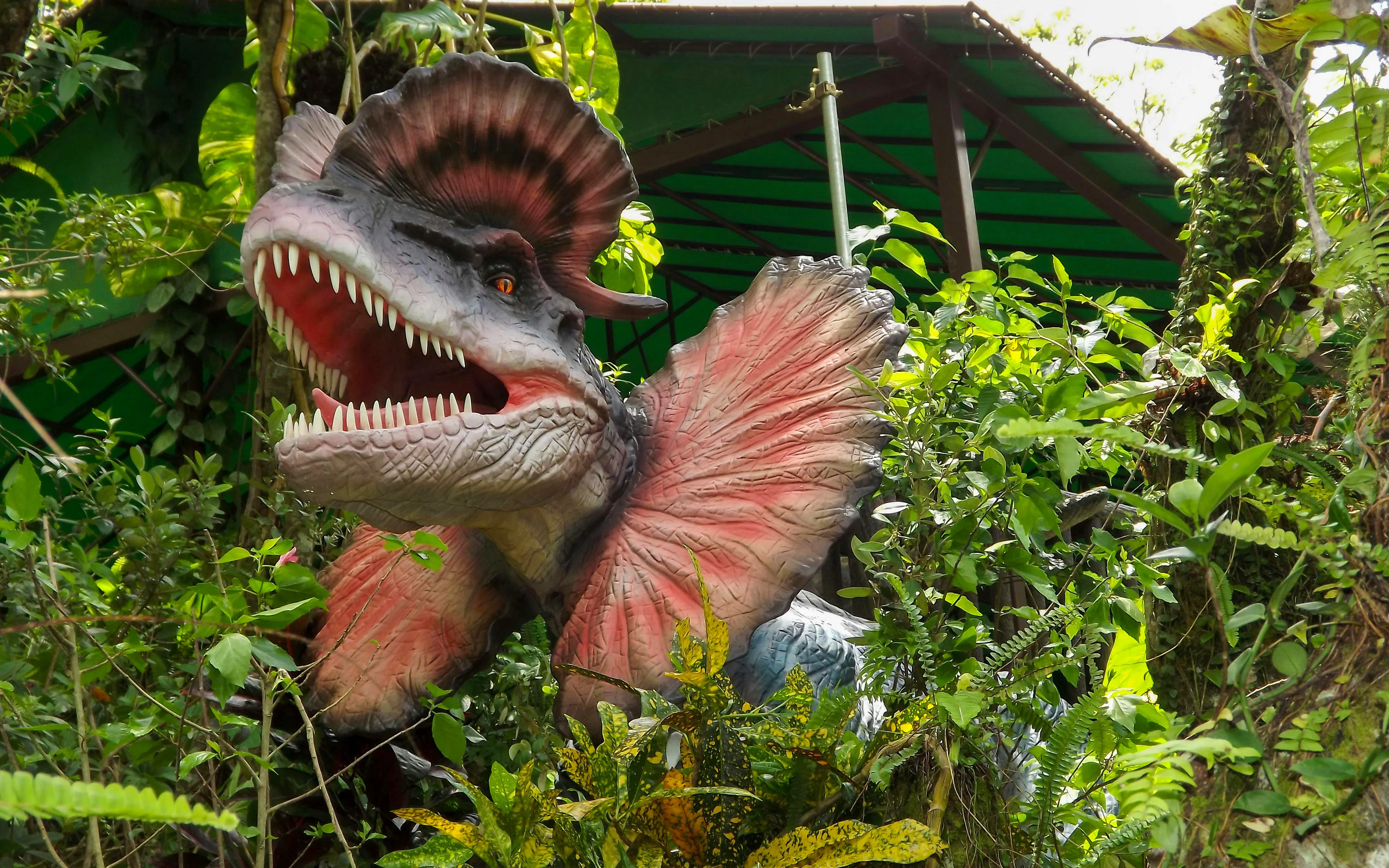 Dinosaur sculpture in lush greenery at Okashigoten Nago Dino Park Yanbaru Subtropical Forest.