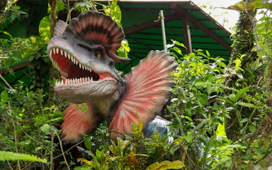 Dinosaur sculpture in lush greenery at Okashigoten Nago Dino Park Yanbaru Subtropical Forest.