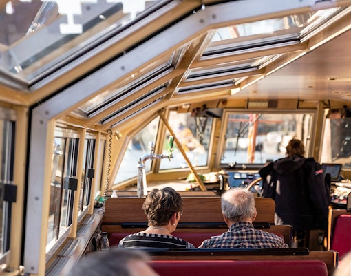 Interior of a canal boat with passengers on an Amsterdam Food & History Tour.