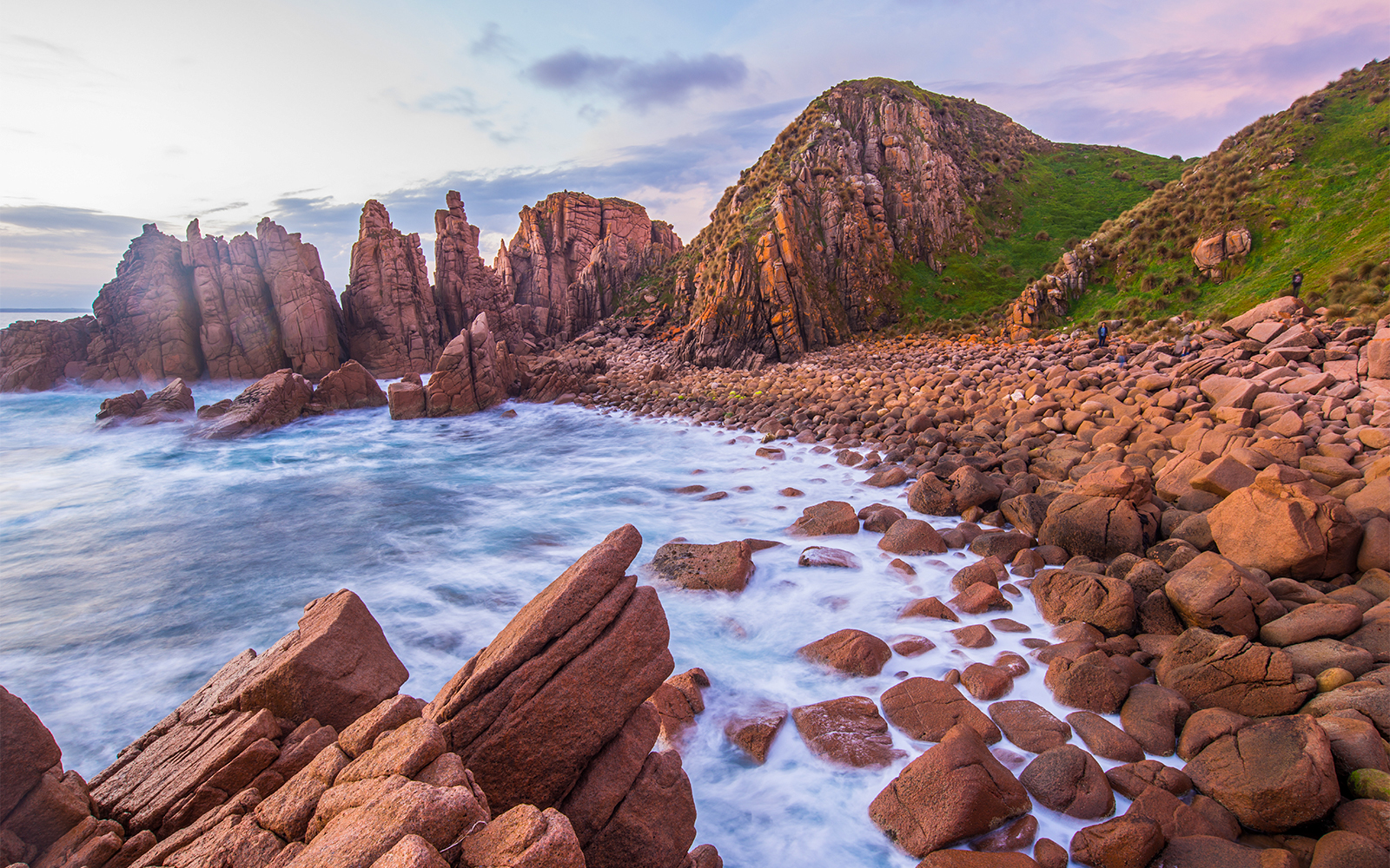 Rocky coastline and ocean waves at sunset on Churchill Island, Australia.