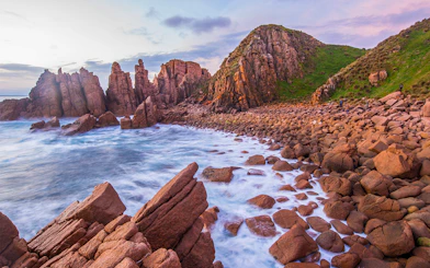 Rocky coastline and ocean waves at sunset on Churchill Island, Australia.
