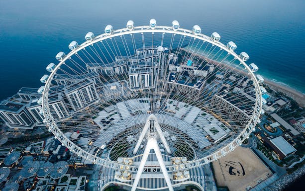 Aerial view of Ain Dubai Ferris wheel overlooking the cityscape and coastline.