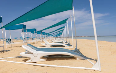 Sun loungers under blue canopies on Bianca Island beach, Hurghada.