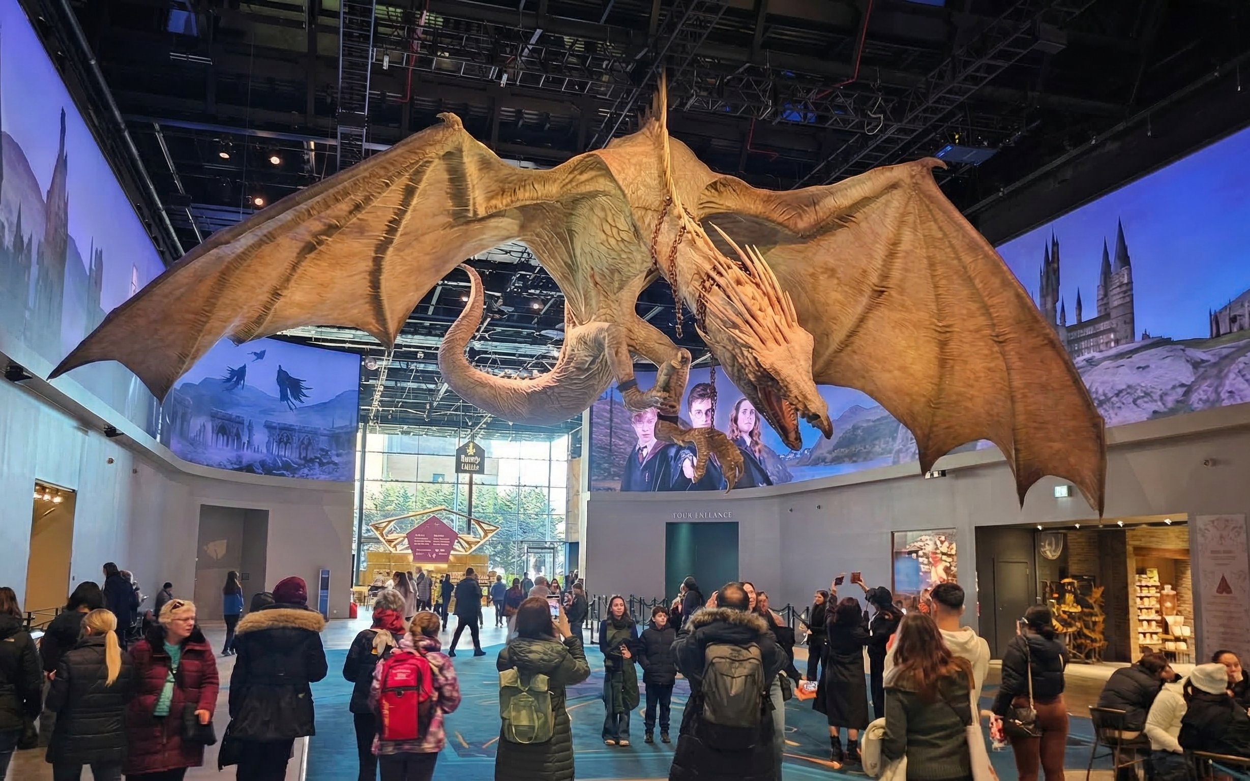 Dragon exhibit at Harry Potter Studio Tour London with visitors exploring the attraction.