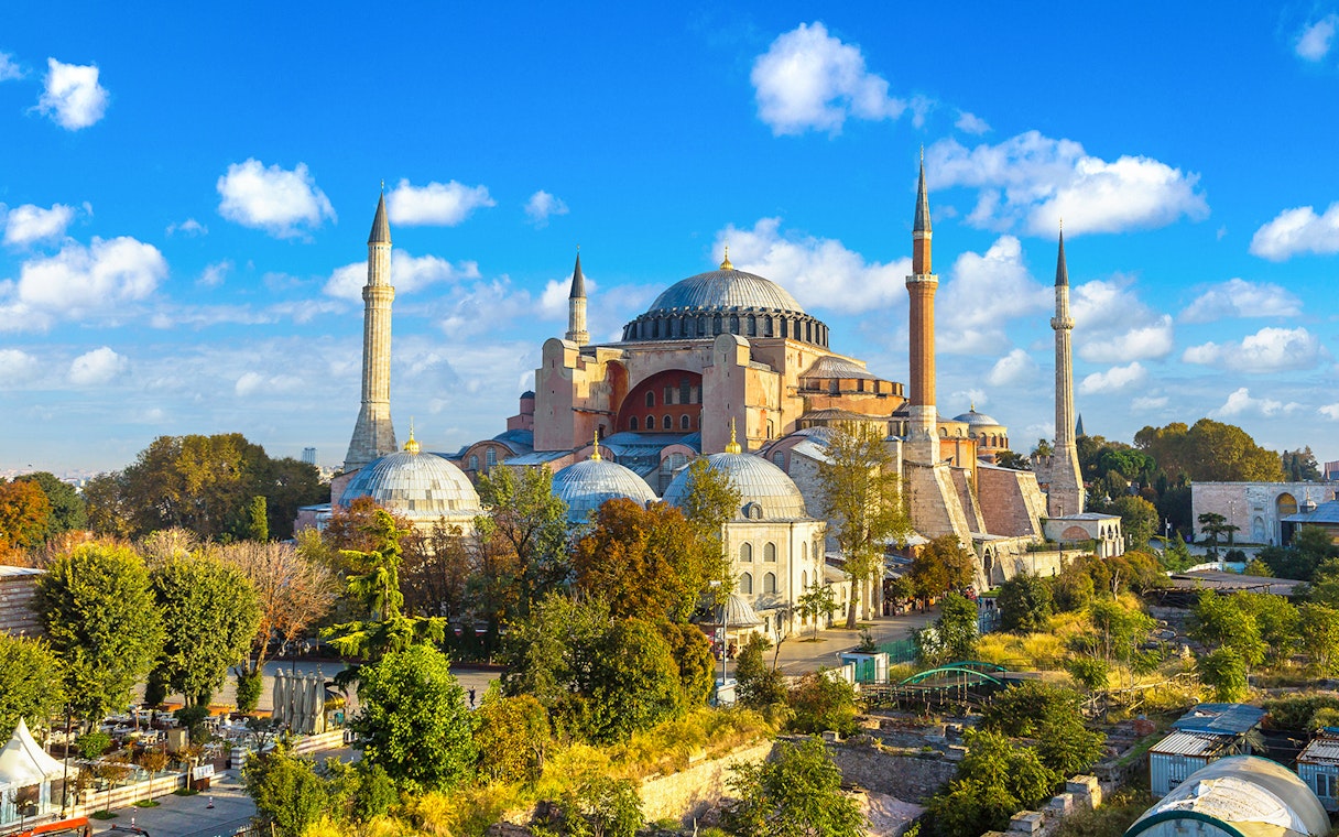 Hagia Sophia in Istanbul with minarets and domes under a blue sky.