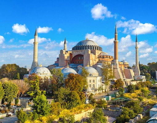 Hagia Sophia in Istanbul with minarets and domes under a blue sky.