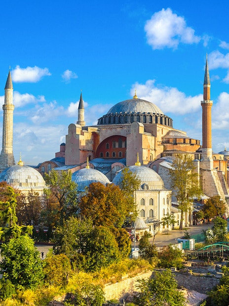 Hagia Sophia in Istanbul with minarets and domes under a blue sky.