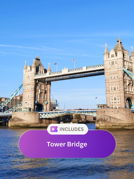 Tower Bridge spanning the River Thames in London under a clear blue sky.