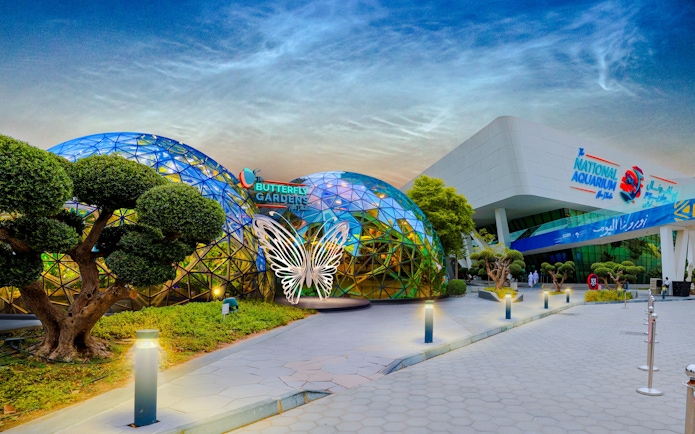 Butterfly Garden entrance with glass domes and butterfly sculpture, adjacent to National Aquarium.