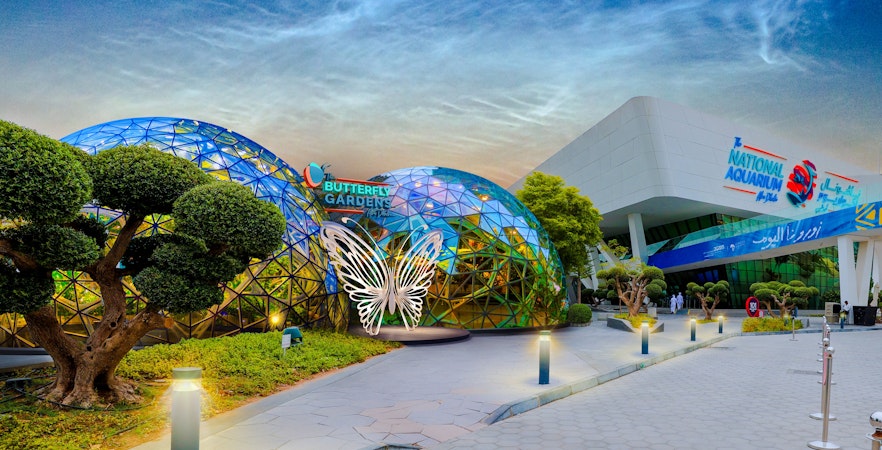 Butterfly Garden entrance with glass domes and butterfly sculpture, adjacent to National Aquarium.