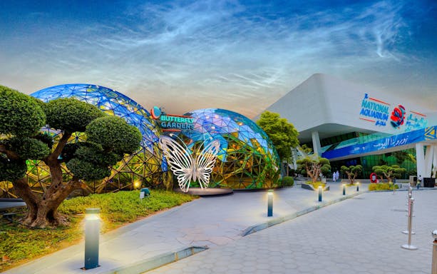 Butterfly Garden entrance with glass domes and butterfly sculpture, adjacent to National Aquarium.