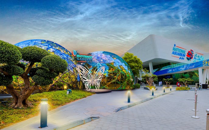 Butterfly Garden entrance with glass domes and butterfly sculpture, adjacent to National Aquarium.