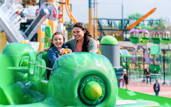 Visitors enjoying GREEN LANTERN™ Emerald Flight ride at Six Flags Fiesta Texas.