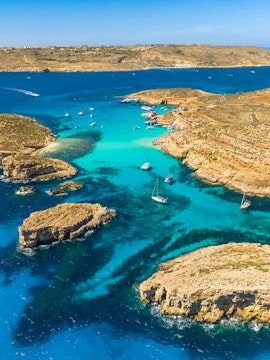 Boats anchored in the clear waters of Blue Lagoon, Comino Island, Malta.
