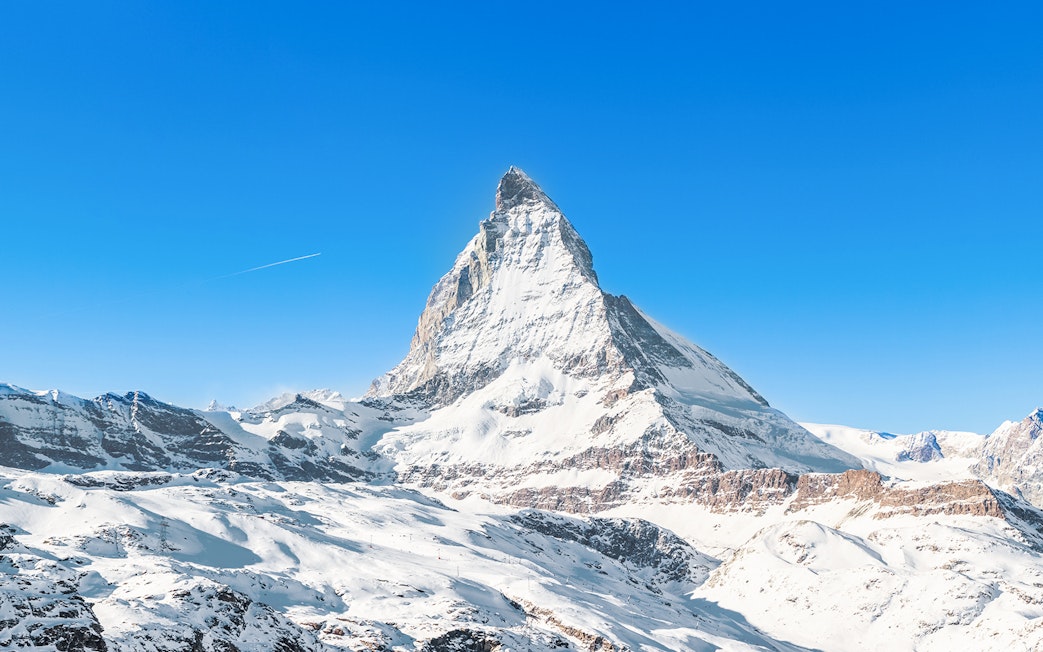 Matterhorn Peak covered in snow under a clear blue sky, Swiss Alps.